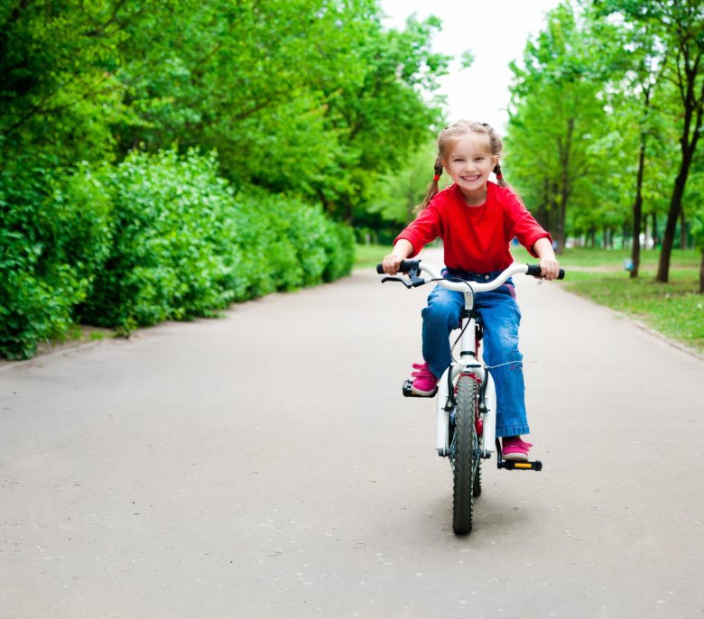 Девочка катается на велосипеде