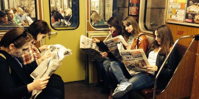 Люди с газетами в метро