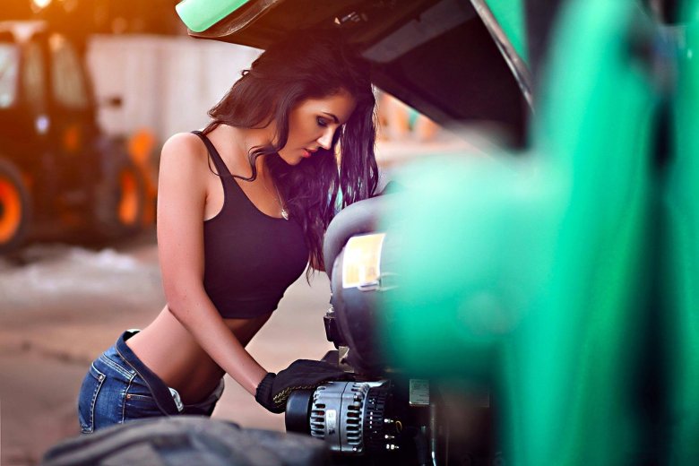 Девушка чинит машину