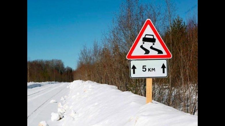 Знак скользкая дорога на дороге